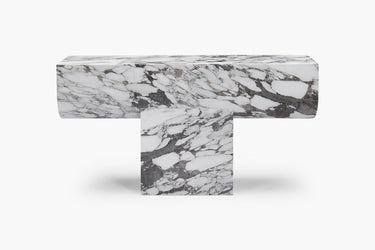 A luxurious white marble console table with grey veining, featuring a bold new material language with clean geometry and soft edges.