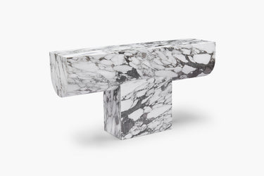 A luxurious white marble console table with grey veining, featuring a bold new material language with clean geometry and soft edges.