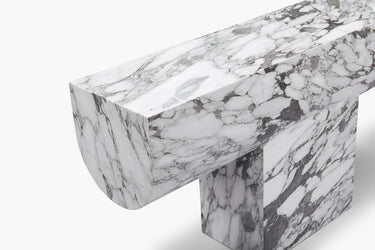 A luxurious white marble console table with grey veining, featuring a bold new material language with clean geometry and soft edges.