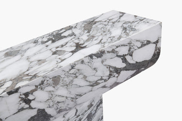A luxurious white marble console table with grey veining, featuring a bold new material language with clean geometry and soft edges.