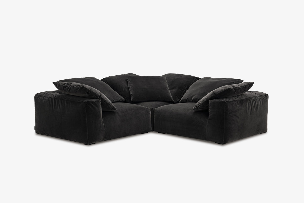 Black velvet corner nook sofa with three modules, studio front view