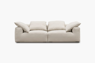 Cream two-piece sofa with plush pillow back cushions, studio view