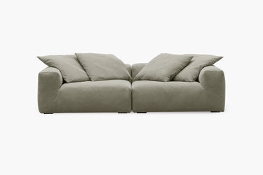 Sage green two-piece sofa with plush pillow back cushions, studio view