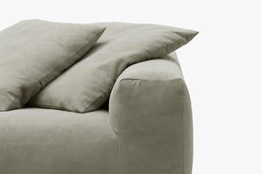 Close-up of sage green sofa arm and cushions, corner detail