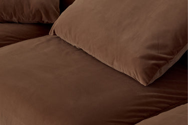 Close-up of chocolate brown velvet sofa cushion, angled view