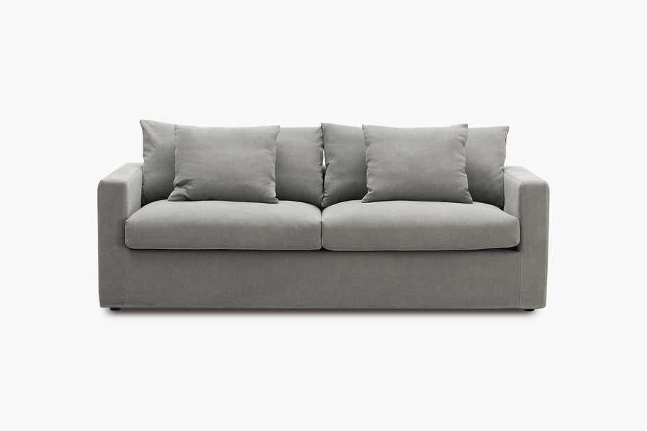 Grey sofa with matching cushions shown from the front in a studio setting.