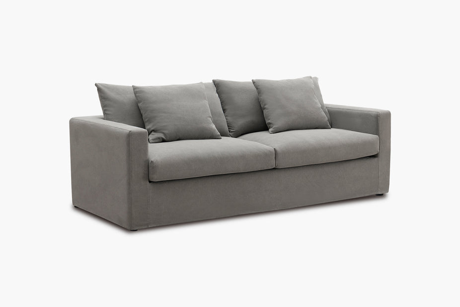 Grey sofa photographed from a three-quarter angle in a studio.