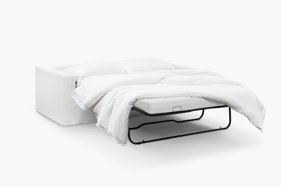 Cream sofa bed shown unfolded at an angle with the mattress frame extended.