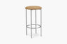 Backless bar stool with tan vinyl seat and metal legs on a white background.