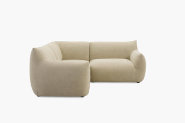 Light taupe L-shaped modular sofa with a corner chaise photographed at an angle.