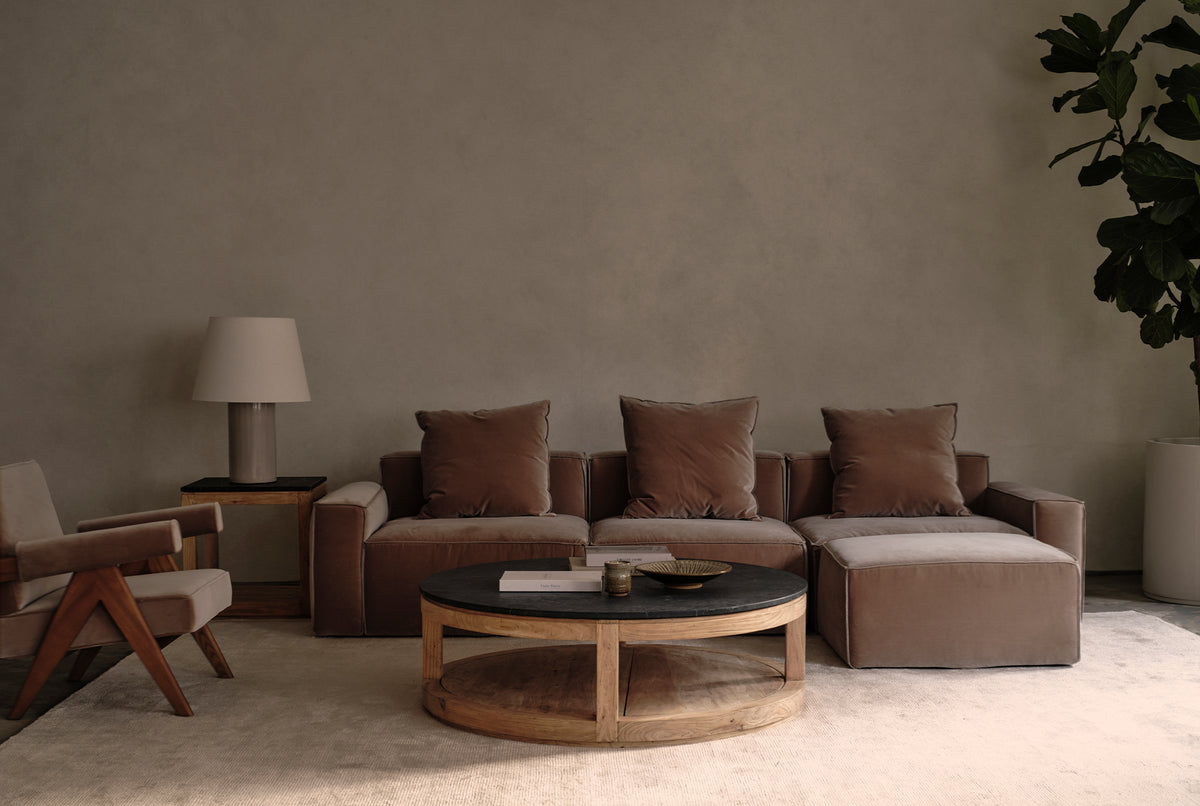 A round coffee table made of black stone and old elm timber