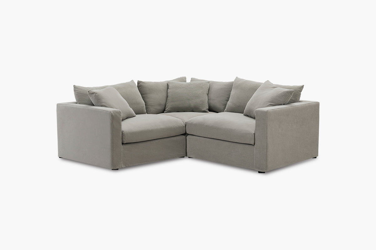 Grey corner sofa with three-piece configuration, studio angled view