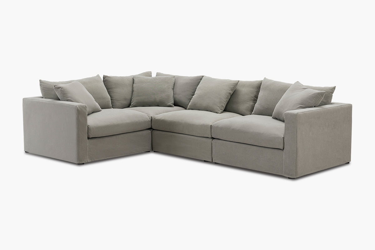 Grey corner sofa with four-piece configuration, studio front view