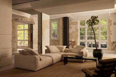 Cream corner sofa in a rustic loft living room with a potted plant