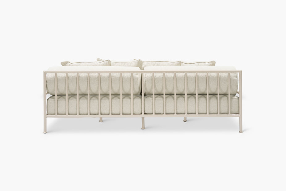 Cream boucle outdoor sofa with a glossy tan frame, rear view