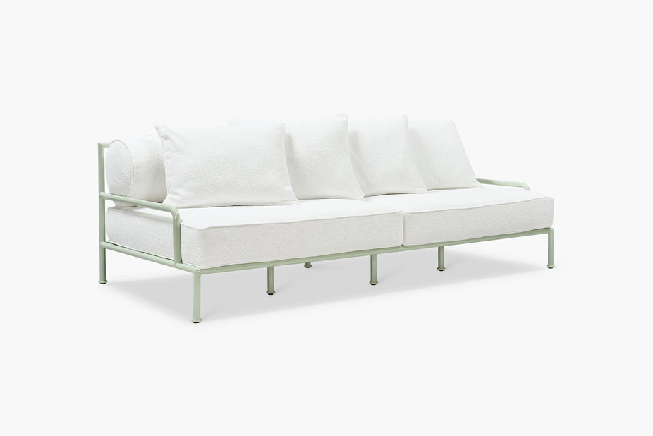 White boucle outdoor sofa with sage green slatted frame, angled view