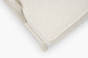 Close-up corner of cream boucle cushion and glossy tan frame leg on a lounge chair