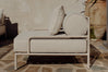 Cream boucle lounge chair beside a large terracotta urn on patio