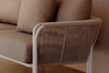 Close-up of white rope armrest and beige linen cushions on patio
