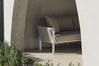 Beige linen sofa under a stone archway beside lavender bushes