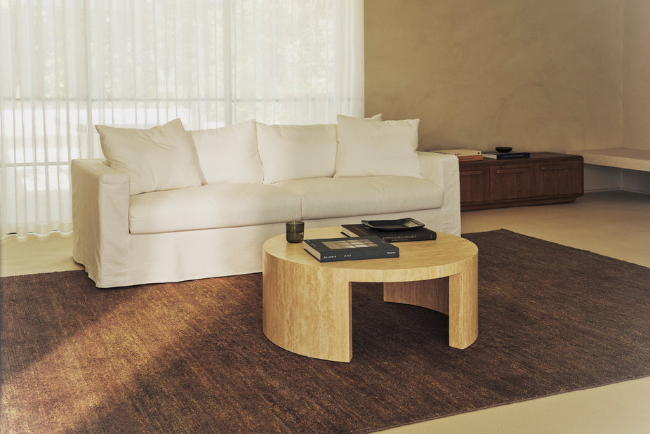 Cream sofa with matching cushions in a bright living room beside a low console.
