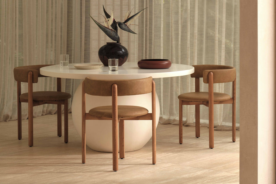 white round dining table with brown vinyl and brown timber chairs