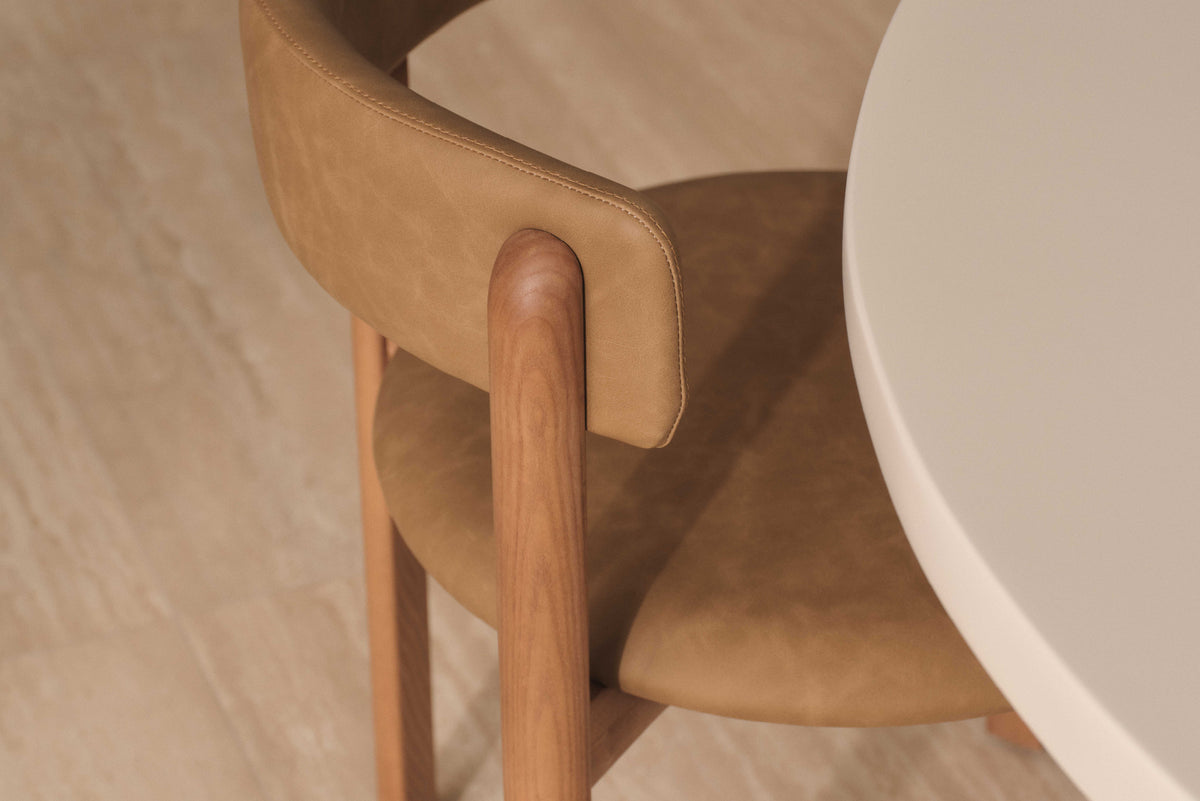 A modern dining chair with a vinyl backrest and seat