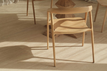 A modern dining chair made of ash timber, with a natural colour