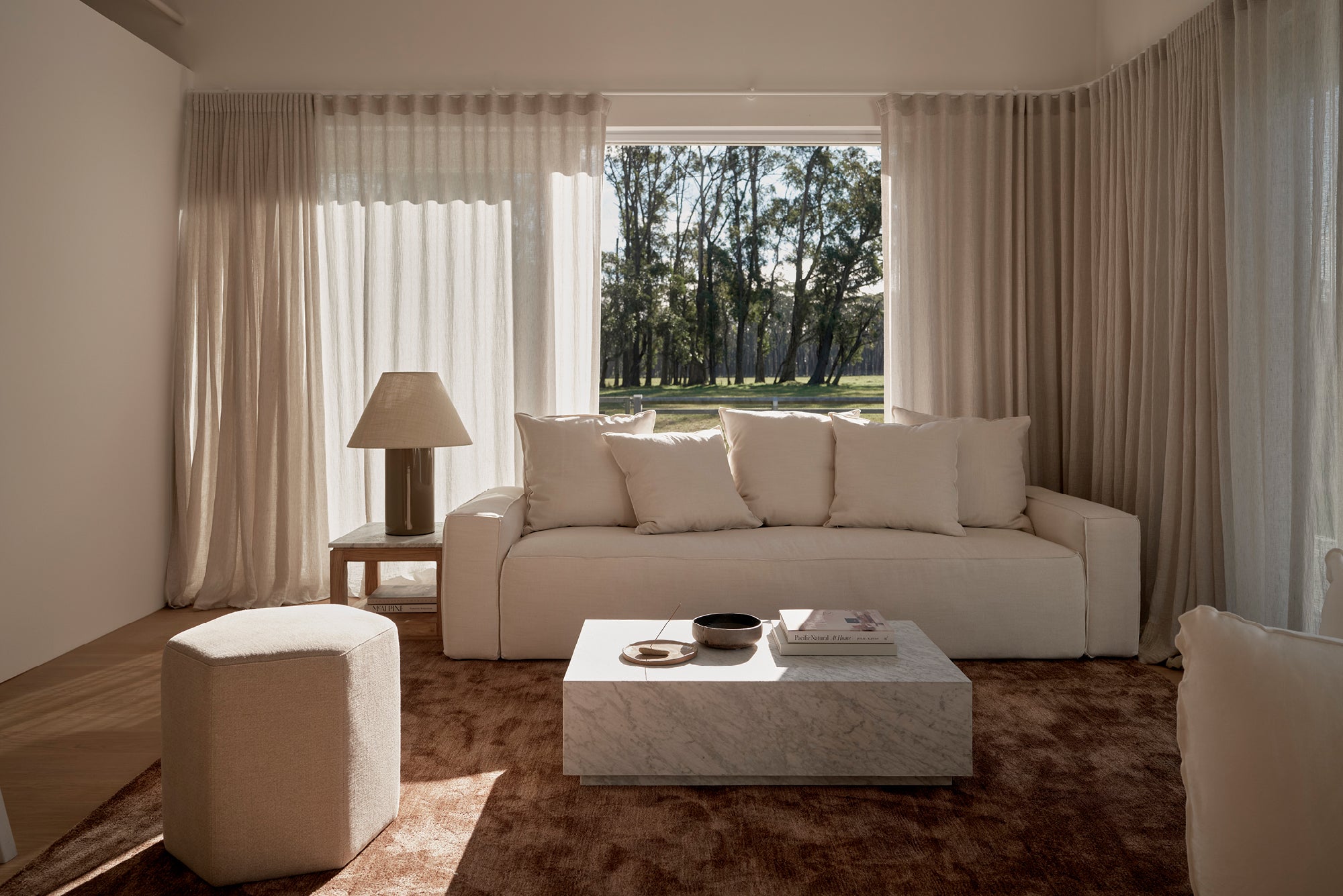 living room setting with white marble coffee table, white sofa, oversized lamp
