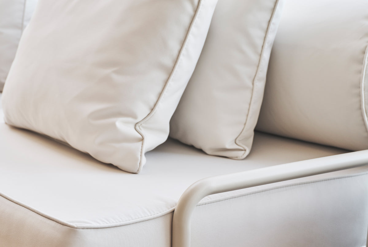 Close-up of cream outdoor sofa cushion fabric and aluminium armrest