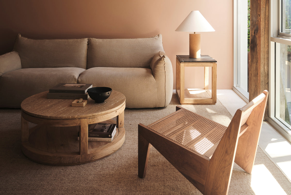 A round coffee table made of natural stone and old elm timber