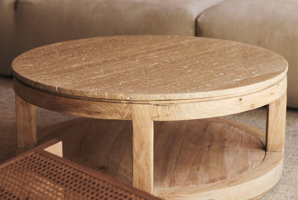 A round coffee table made of natural stone and old elm timber