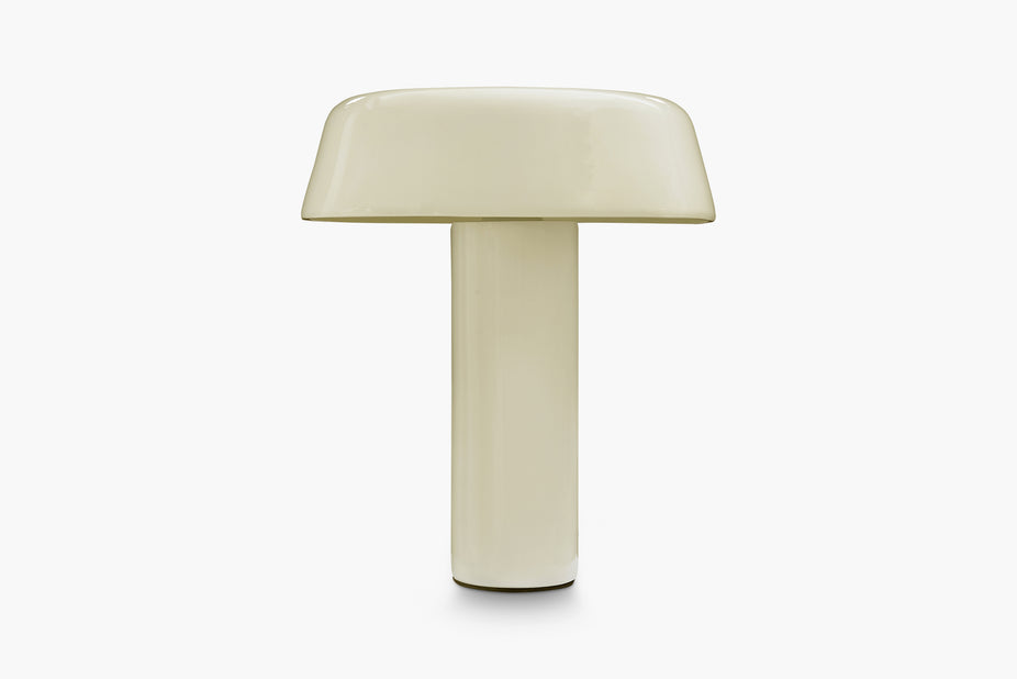 A minimalist mushroom-shaped table lamp with a glossy cream-colored ceramic body, set against a clean white background.