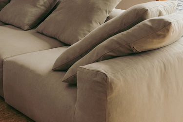 Close-up of taupe sofa cushions and armrest, corner detail